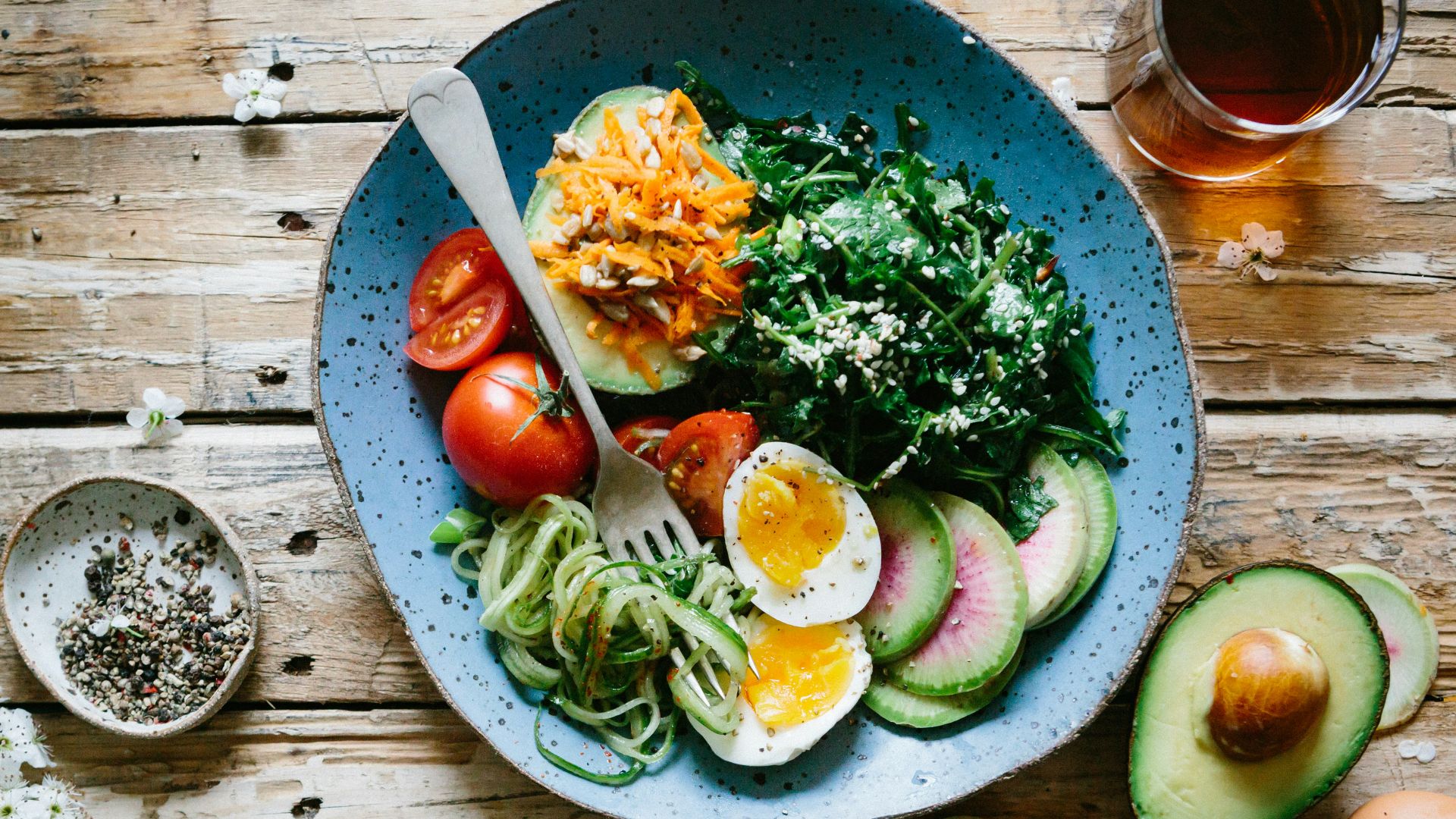 poached egg with vegetables and tomatoes on blue plate