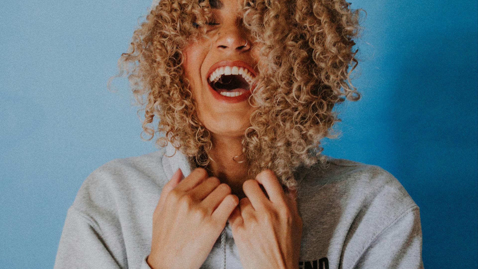 smiling woman wearing gray hoodie