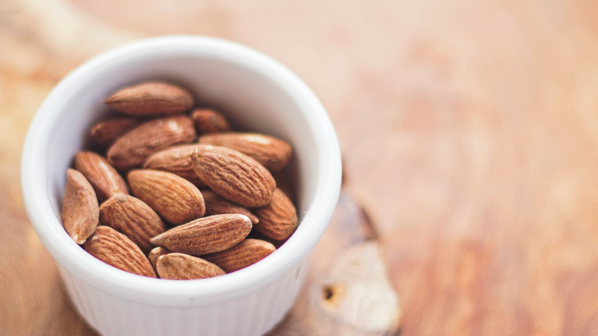 shallow focus photography of almonds in white ceramic bowl
