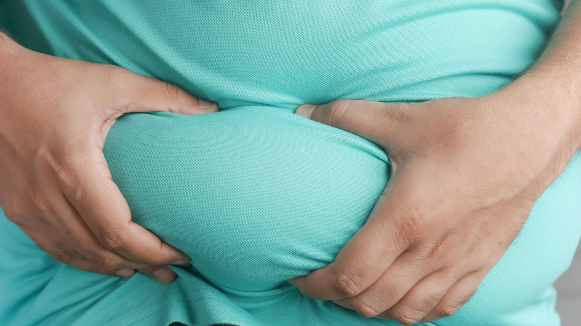 a man holding his stomach with his hands