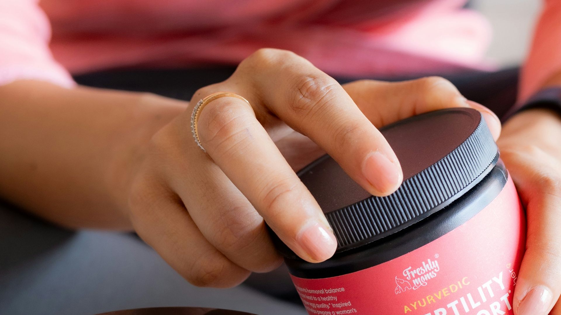 a woman is holding a container of hair products