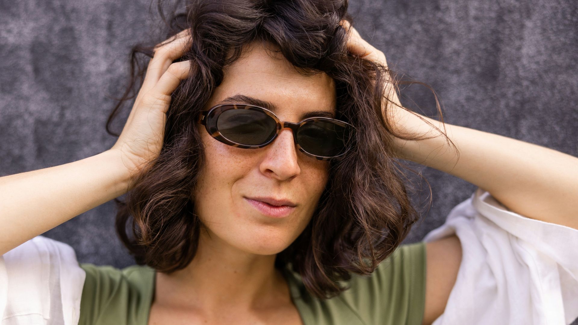 a woman wearing sunglasses and a green shirt