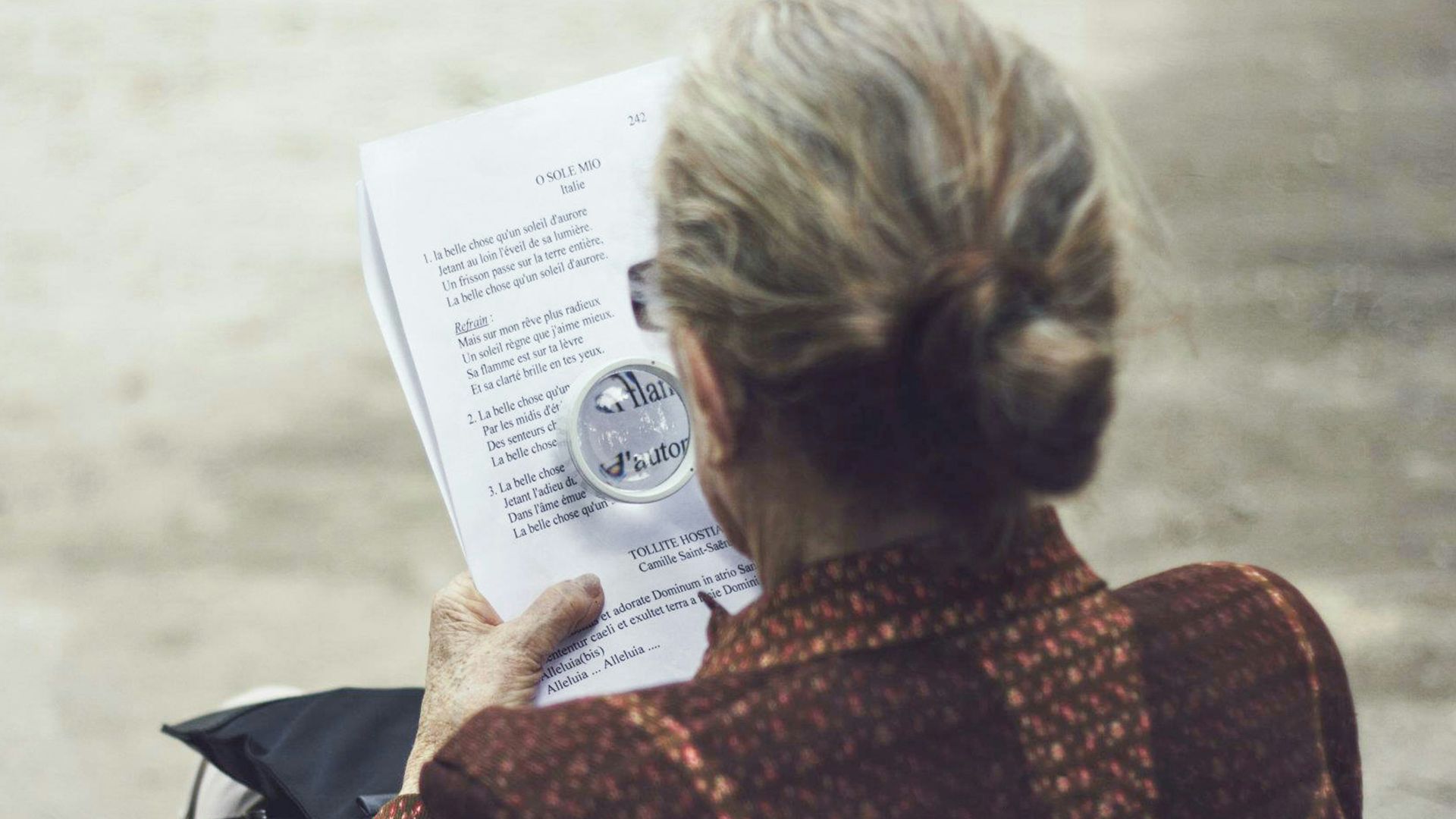 woman in brown top reading paper