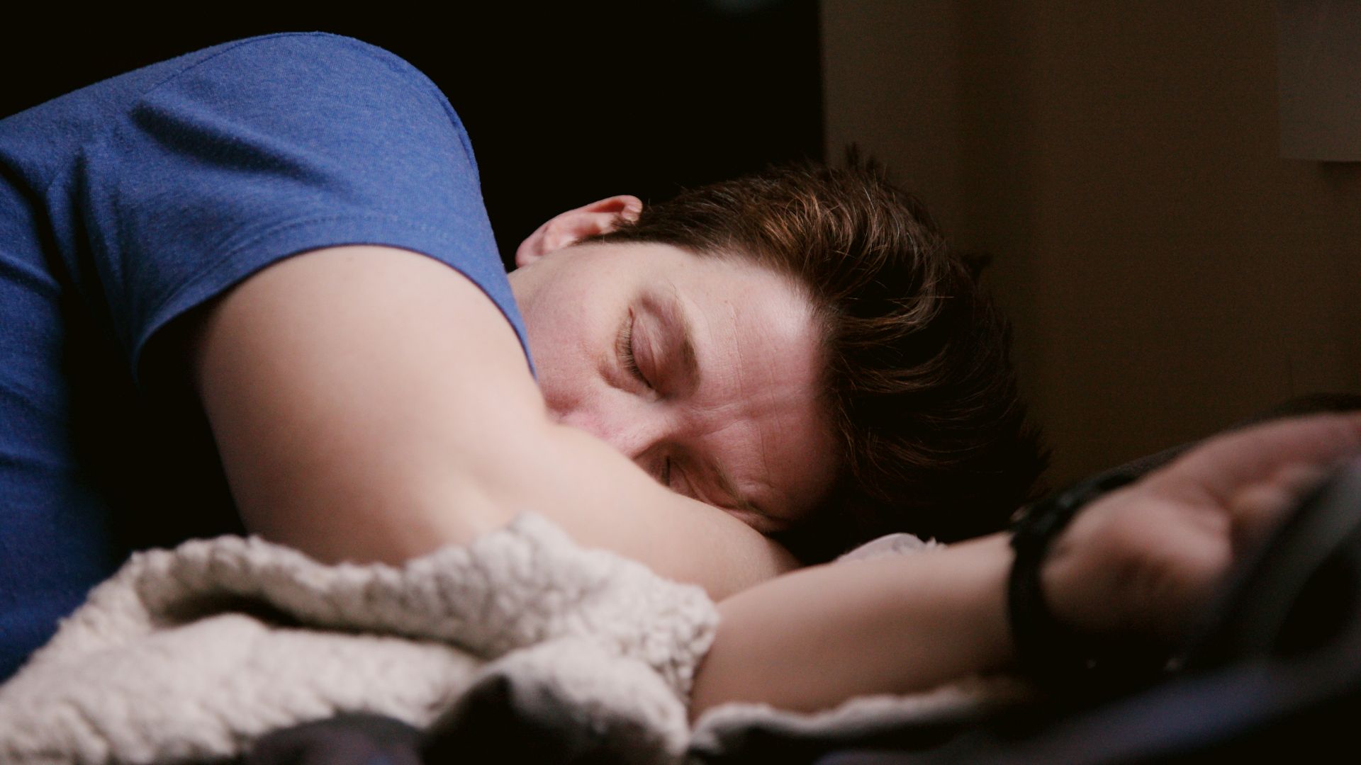 woman in blue shirt lying on bed