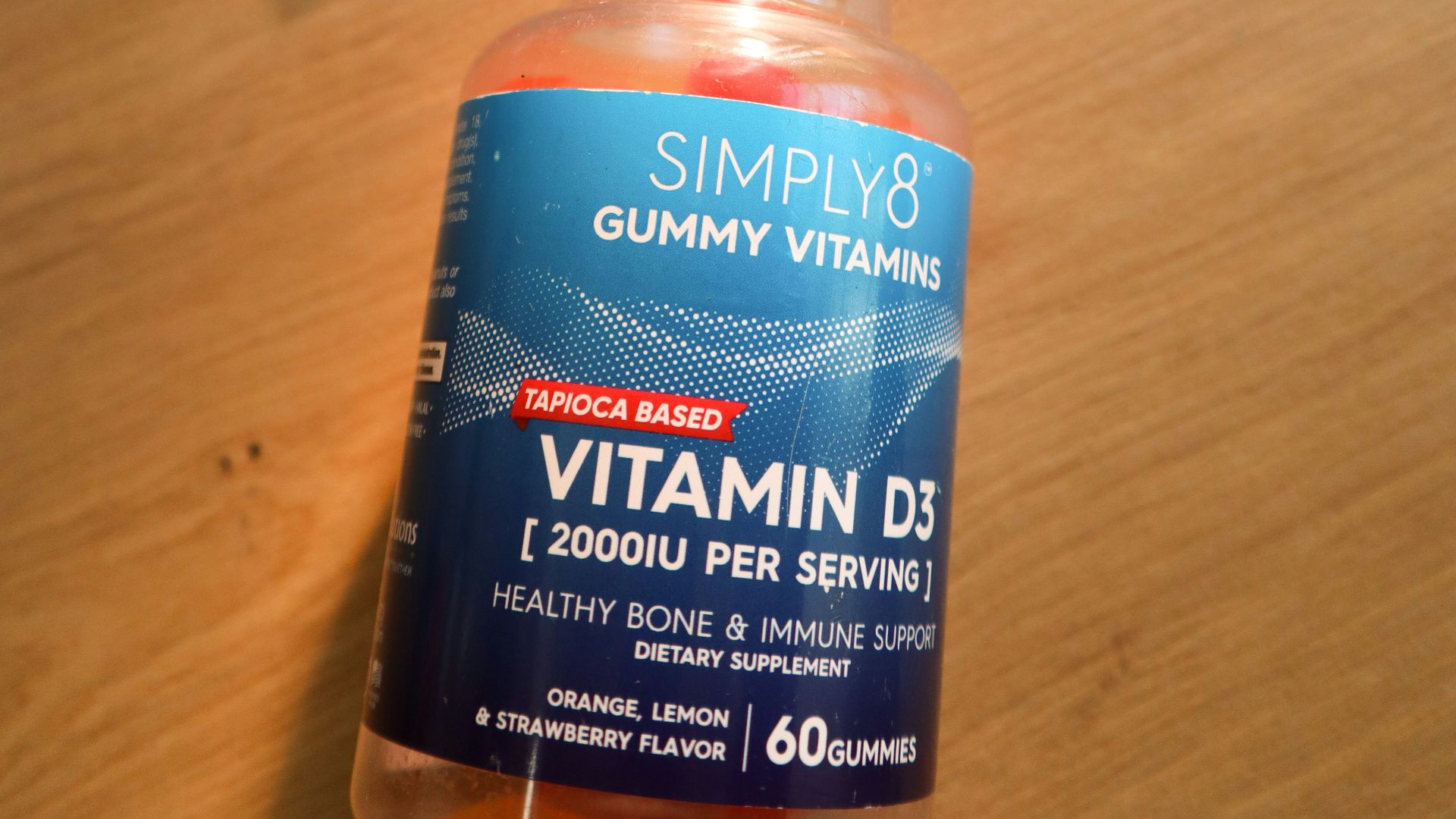 a bottle of gummy vitamins sitting on top of a wooden table