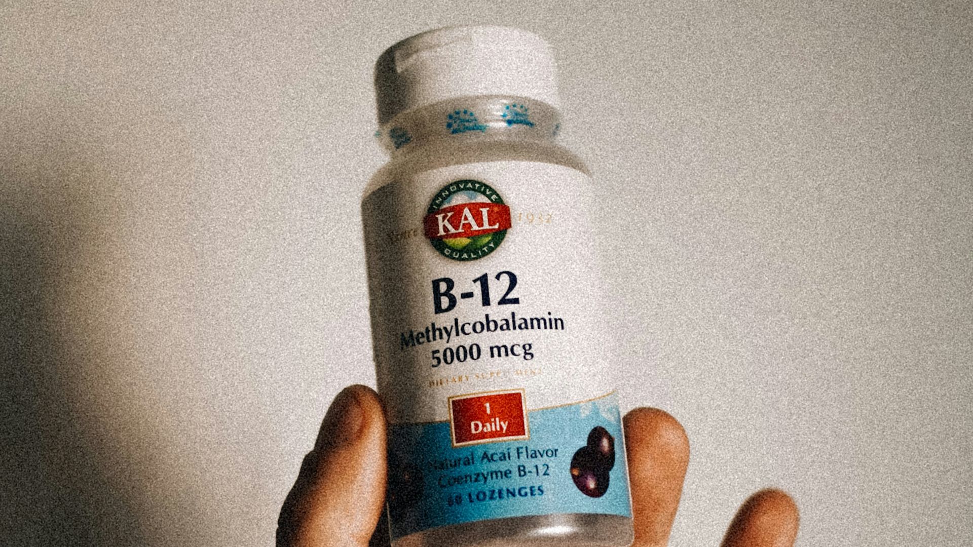 a person holding a bottle of vitamins in their hand