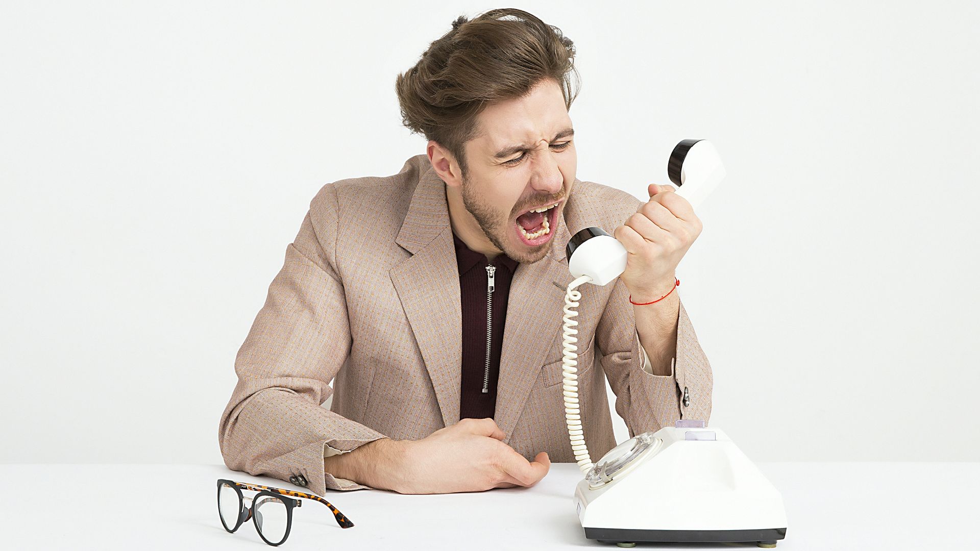 man holding telephone screaming