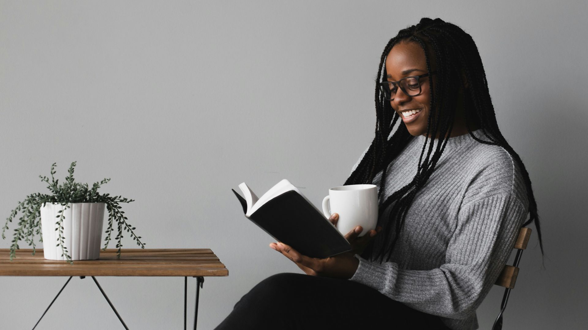 woman in white and black stripe long sleeve shirt sitting on chair