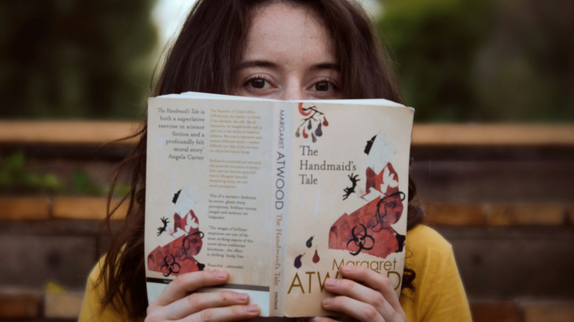woman in yellow shirt holding white paper