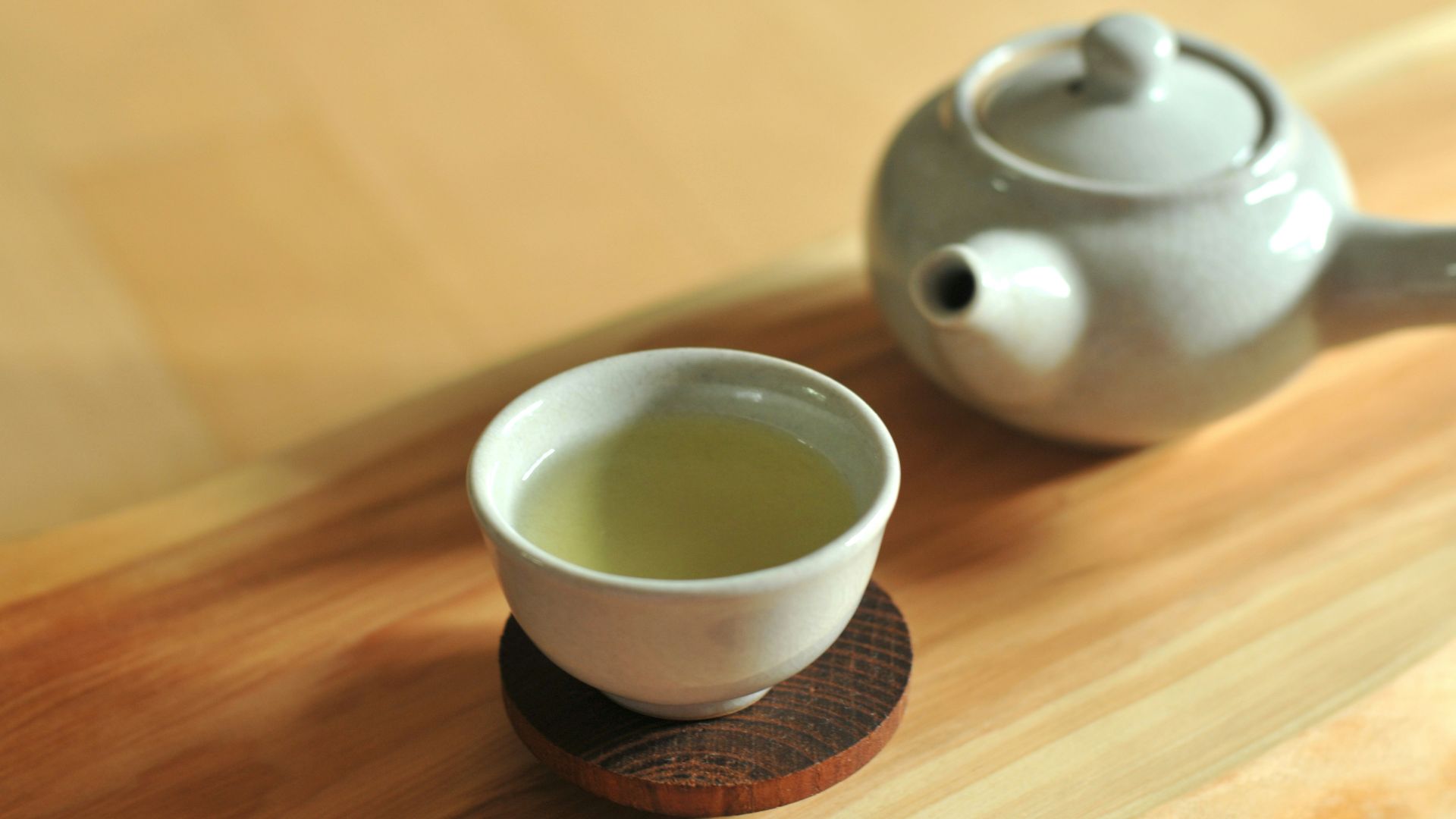 white ceramic teacup on brown wooden table