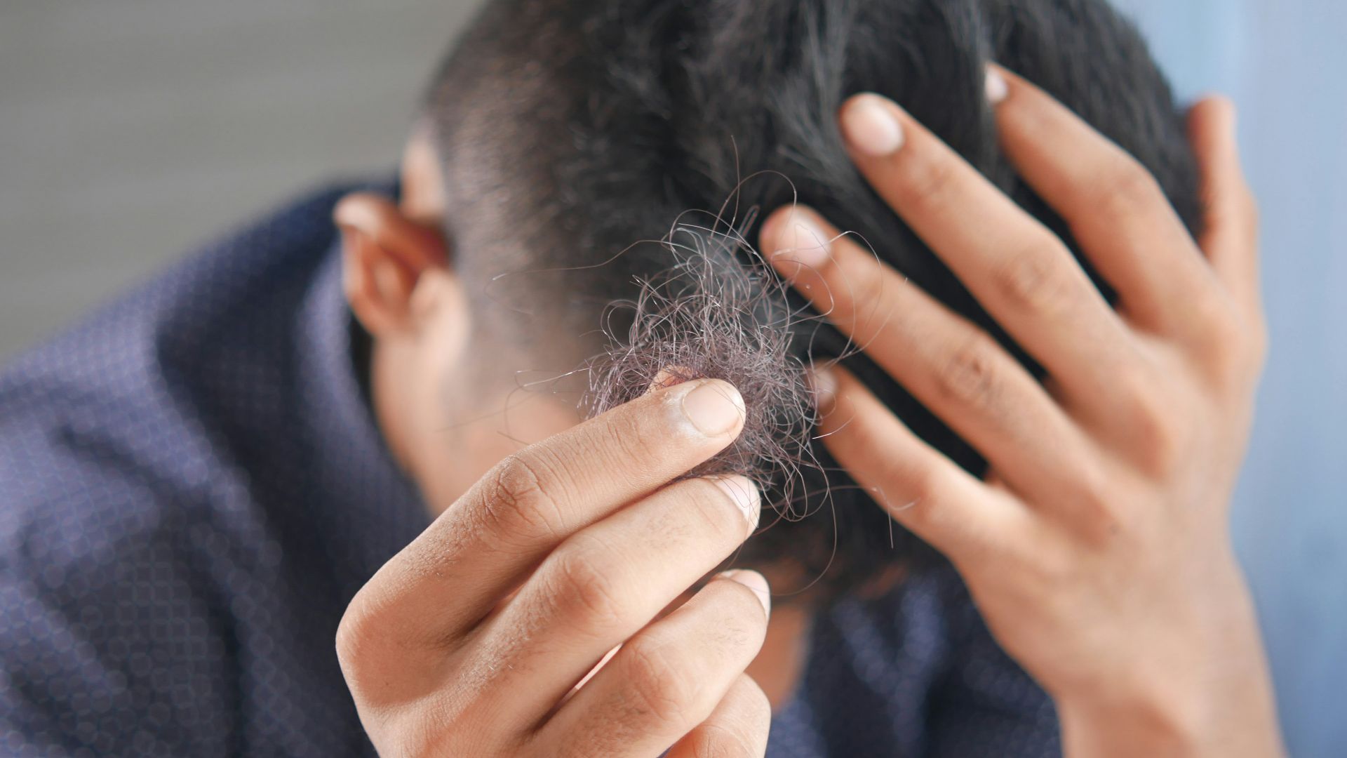 a man is combing his hair with his hands