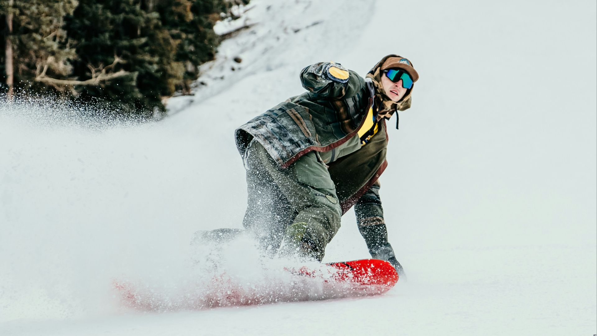 person in black and white jacket riding red snowboard on snow covered ground during daytime