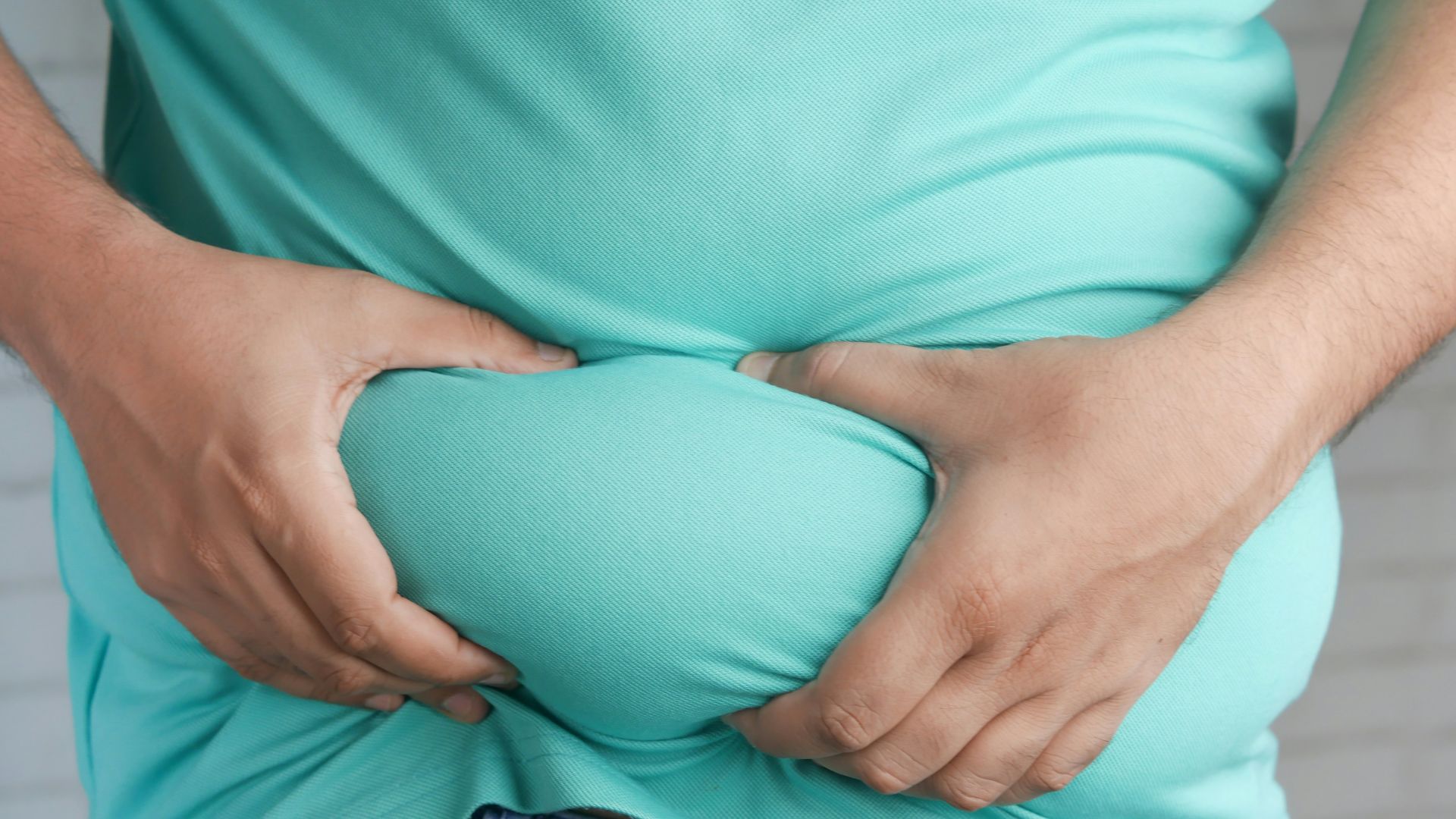 a man holding his stomach with his hands