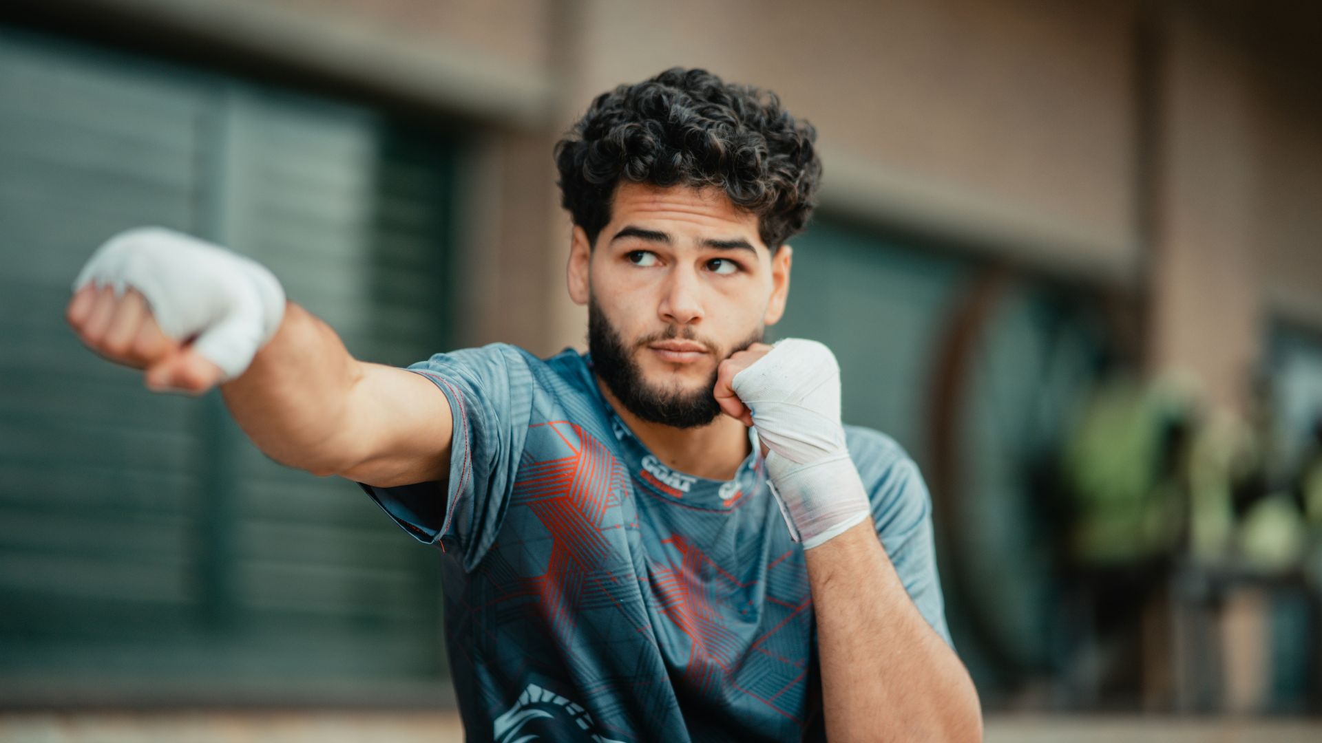 A man with a beard and gloves on holding a tennis racquet
