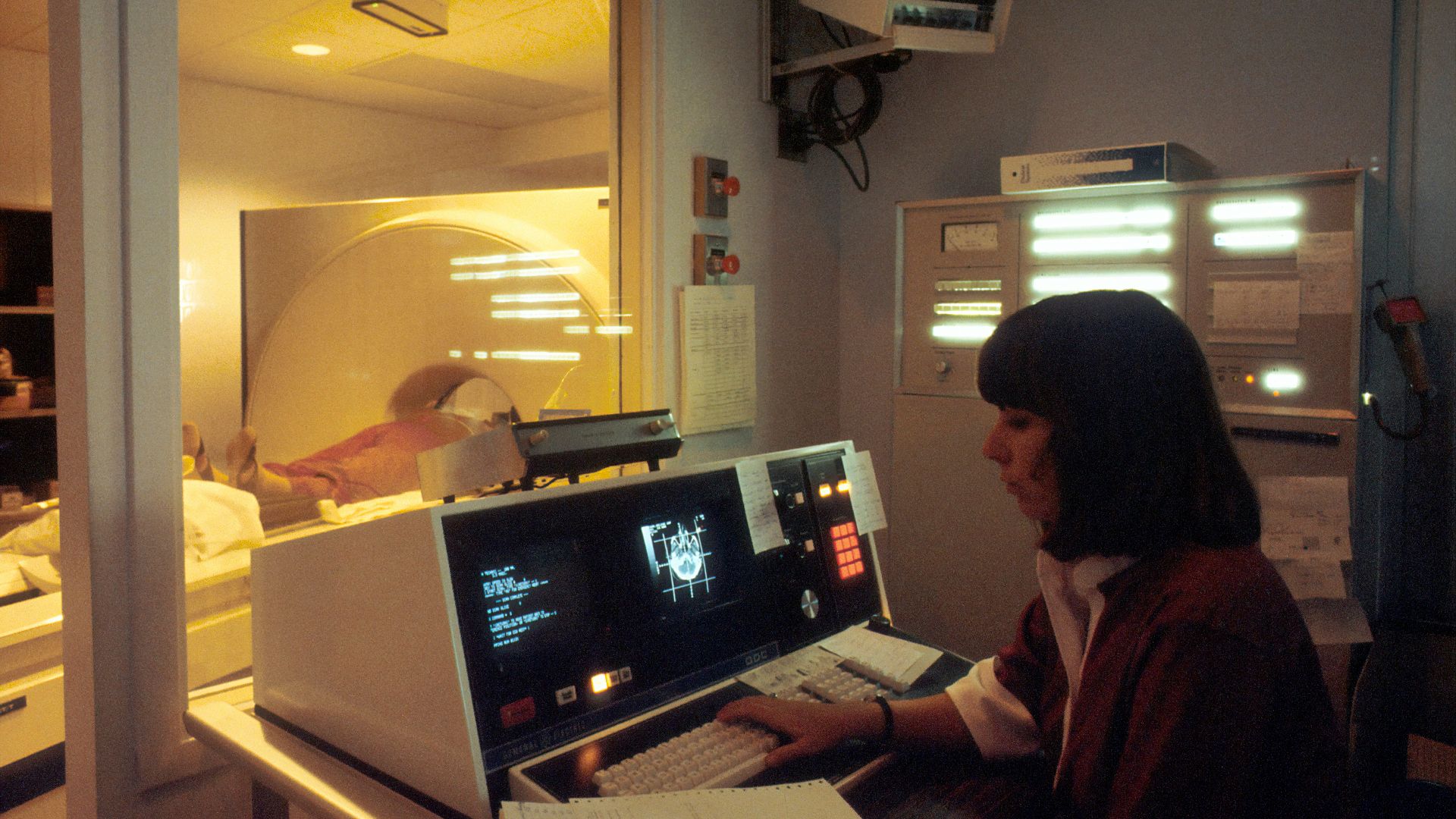 woman in red shirt sitting in front of computer