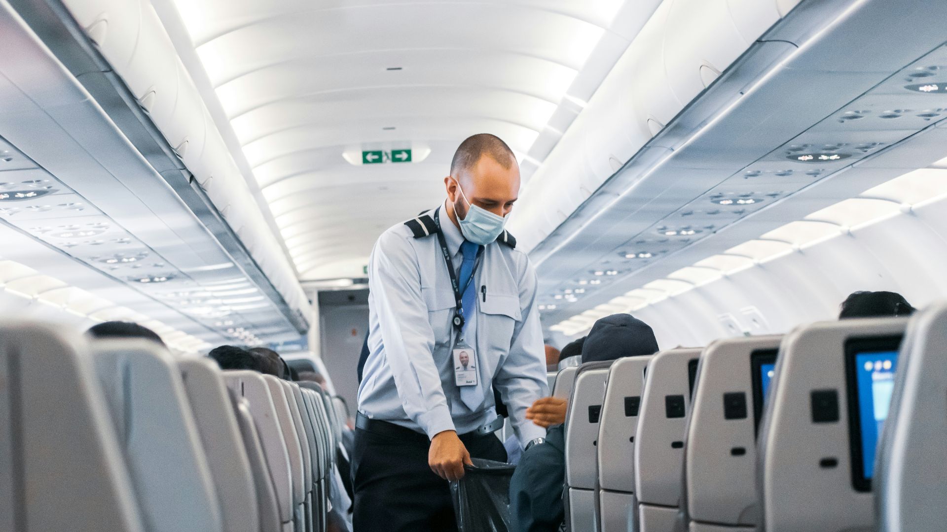 man in blue dress shirt standing in airplane