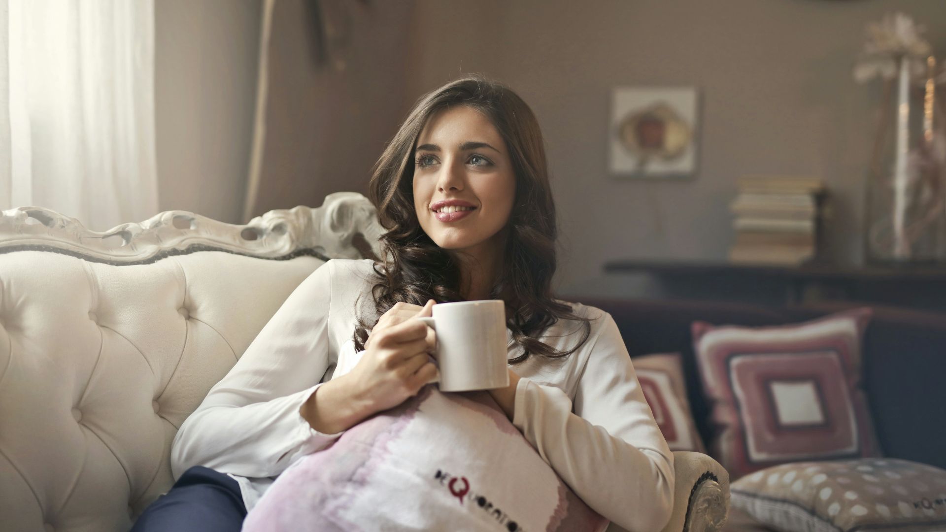 woman holding mug sitting on sofa