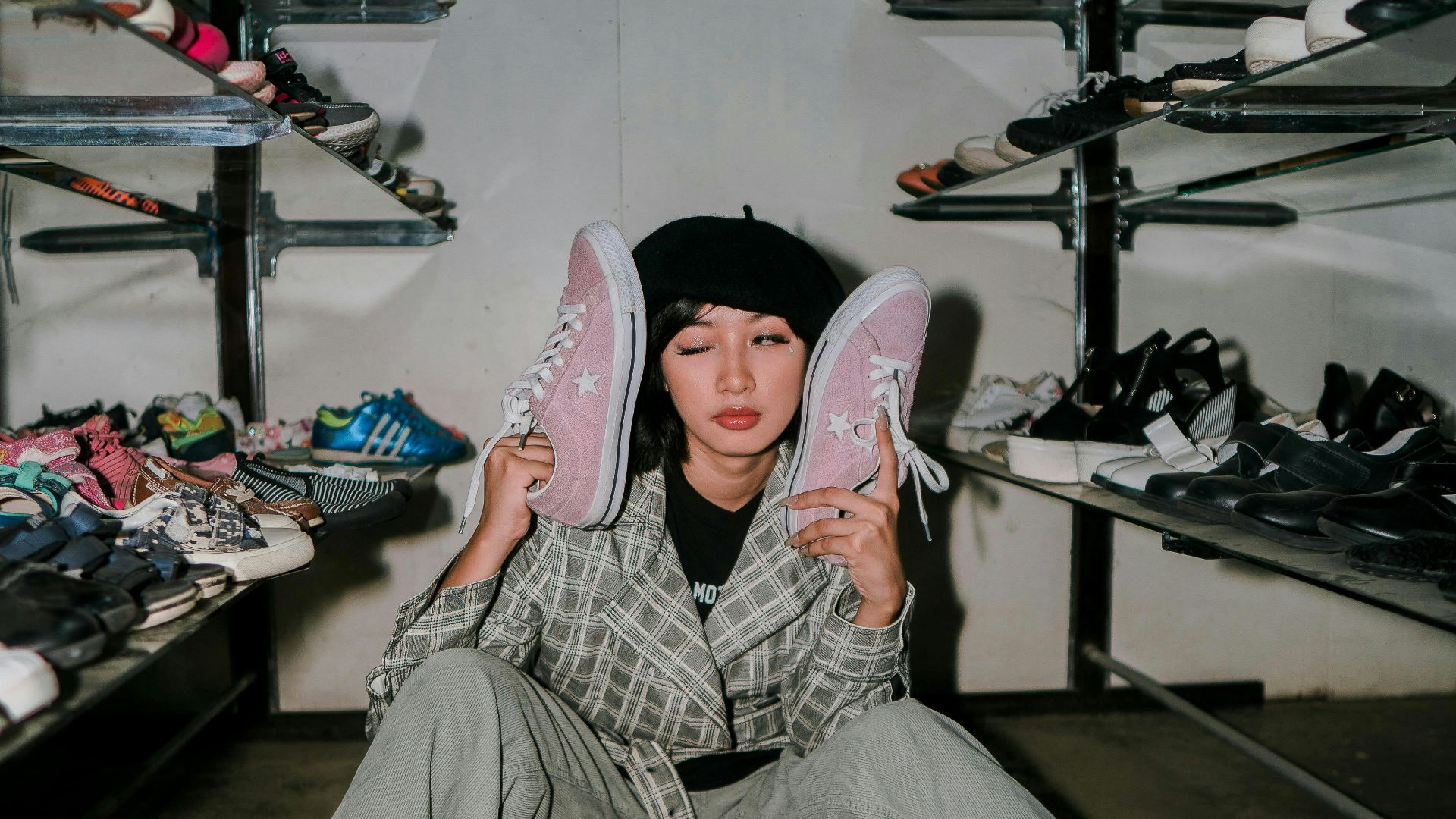 A person sitting on the ground holding a pair of shoes