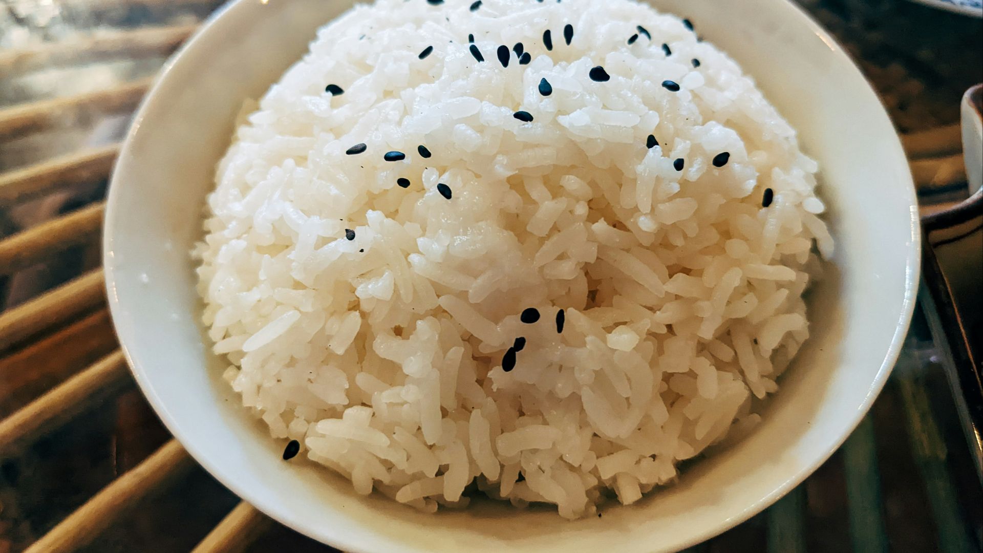 a bowl of white rice with black sesame seeds