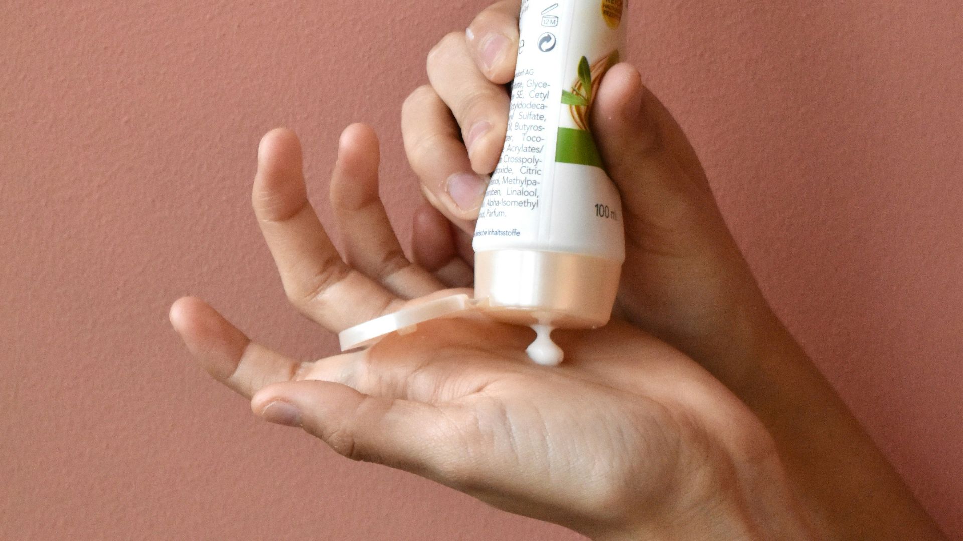 a person holding a tube of toothpaste in their hand