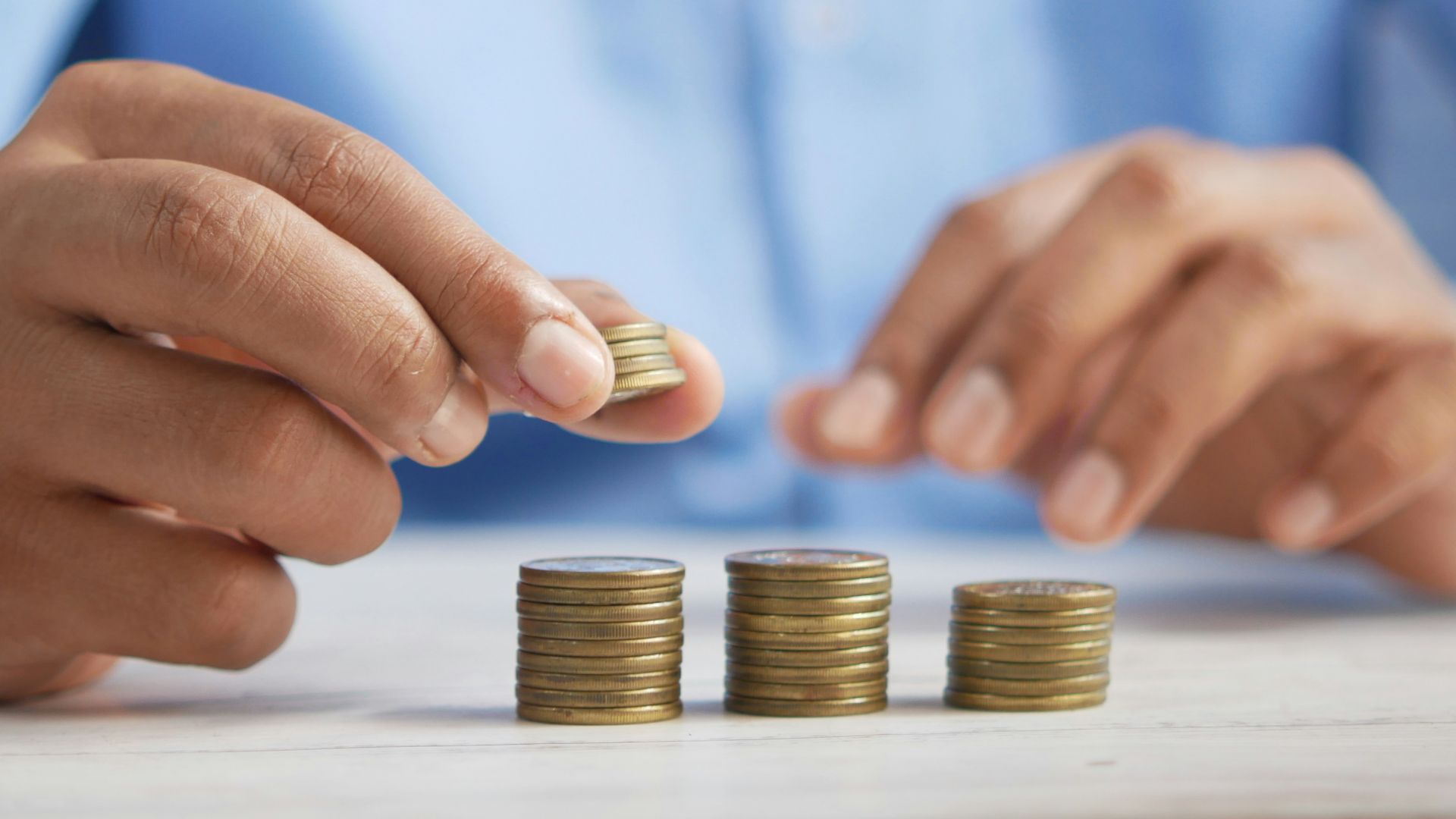 a person stacking coins on top of a table