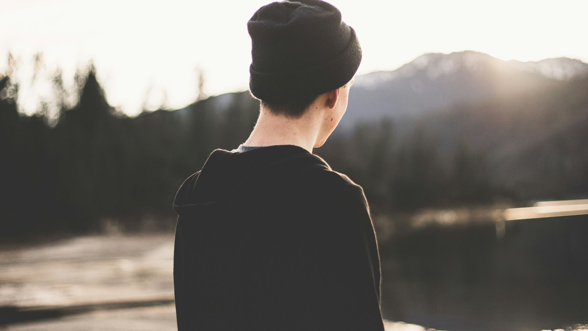 tilt shift lens photography of man standing near body of water