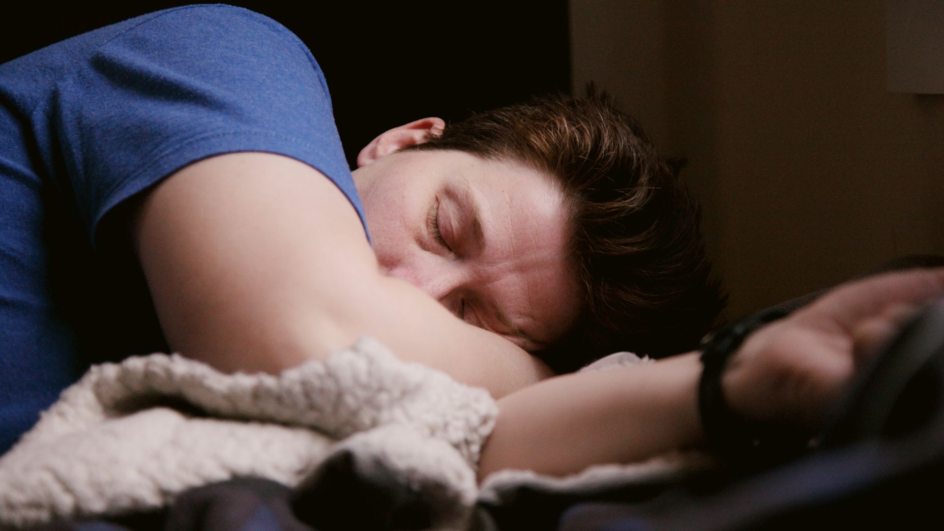 woman in blue shirt lying on bed