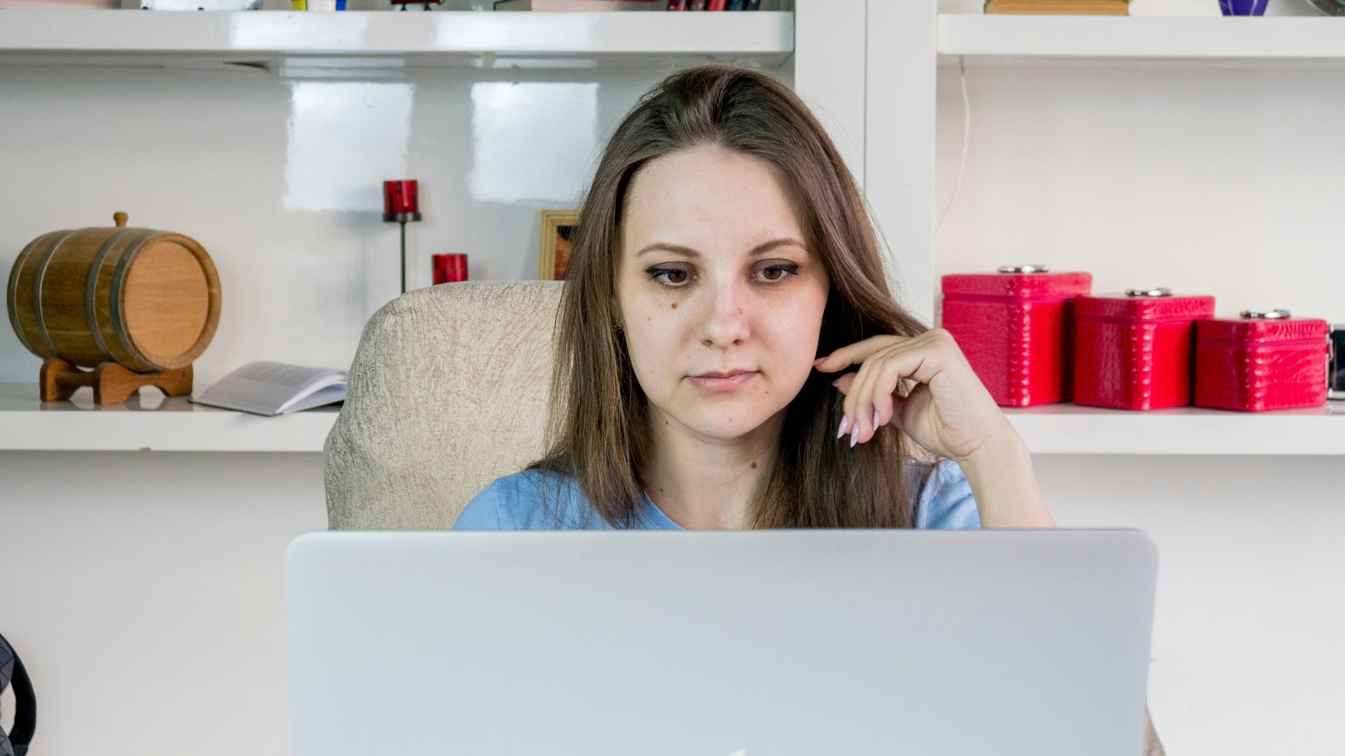 a woman sitting in front of a laptop computer