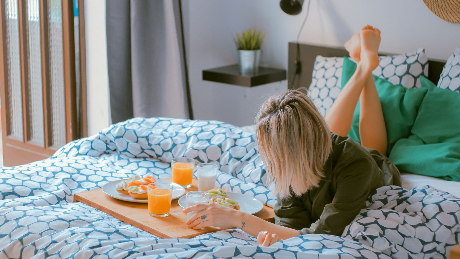 woman lying on bed white holding board