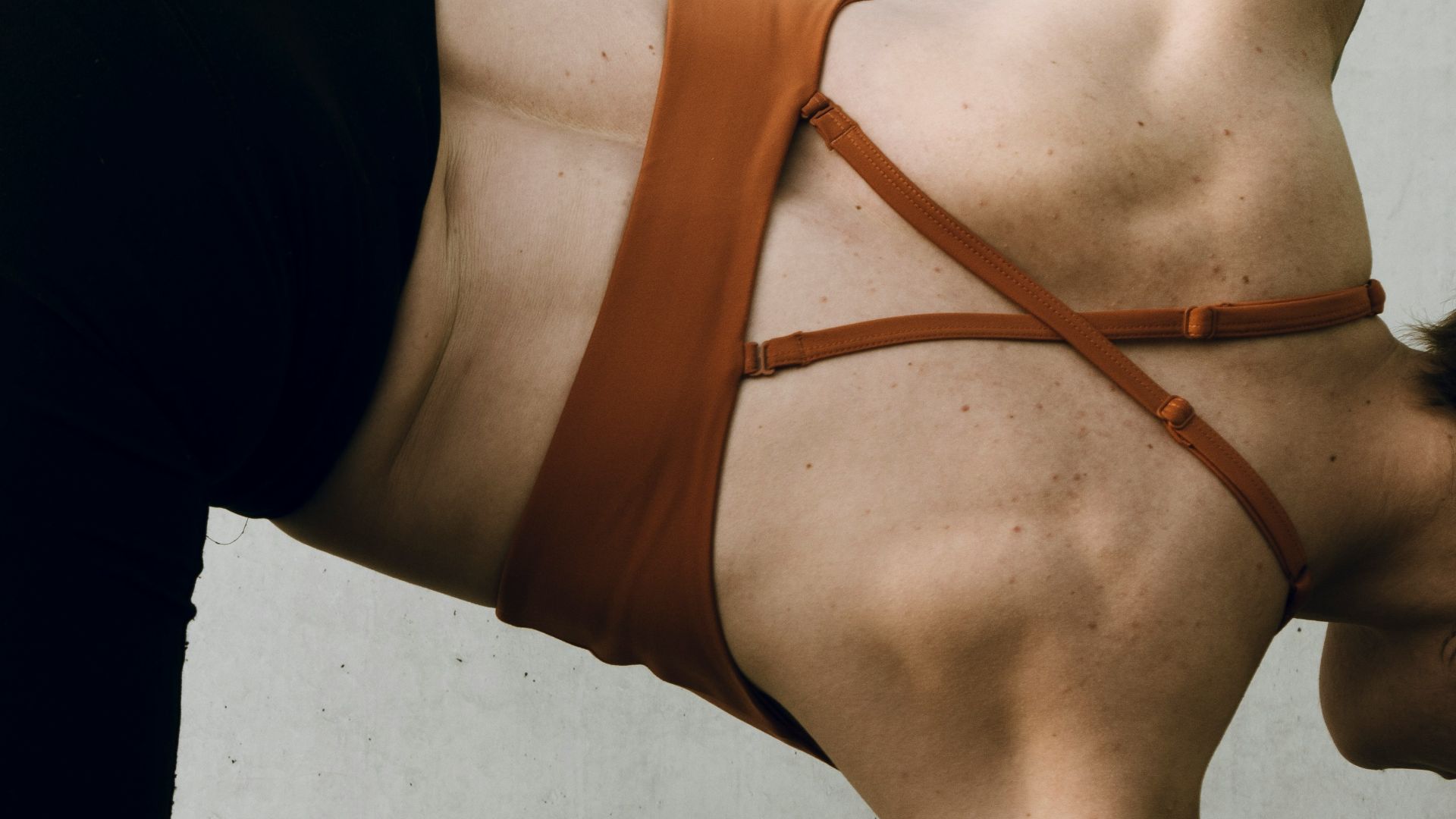a woman in a brown bikini doing a handstand