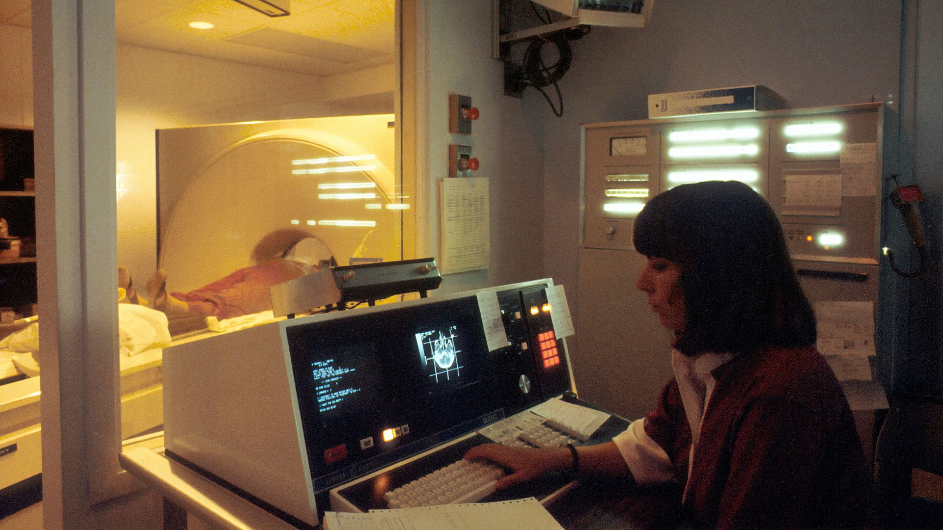 woman in red shirt sitting in front of computer