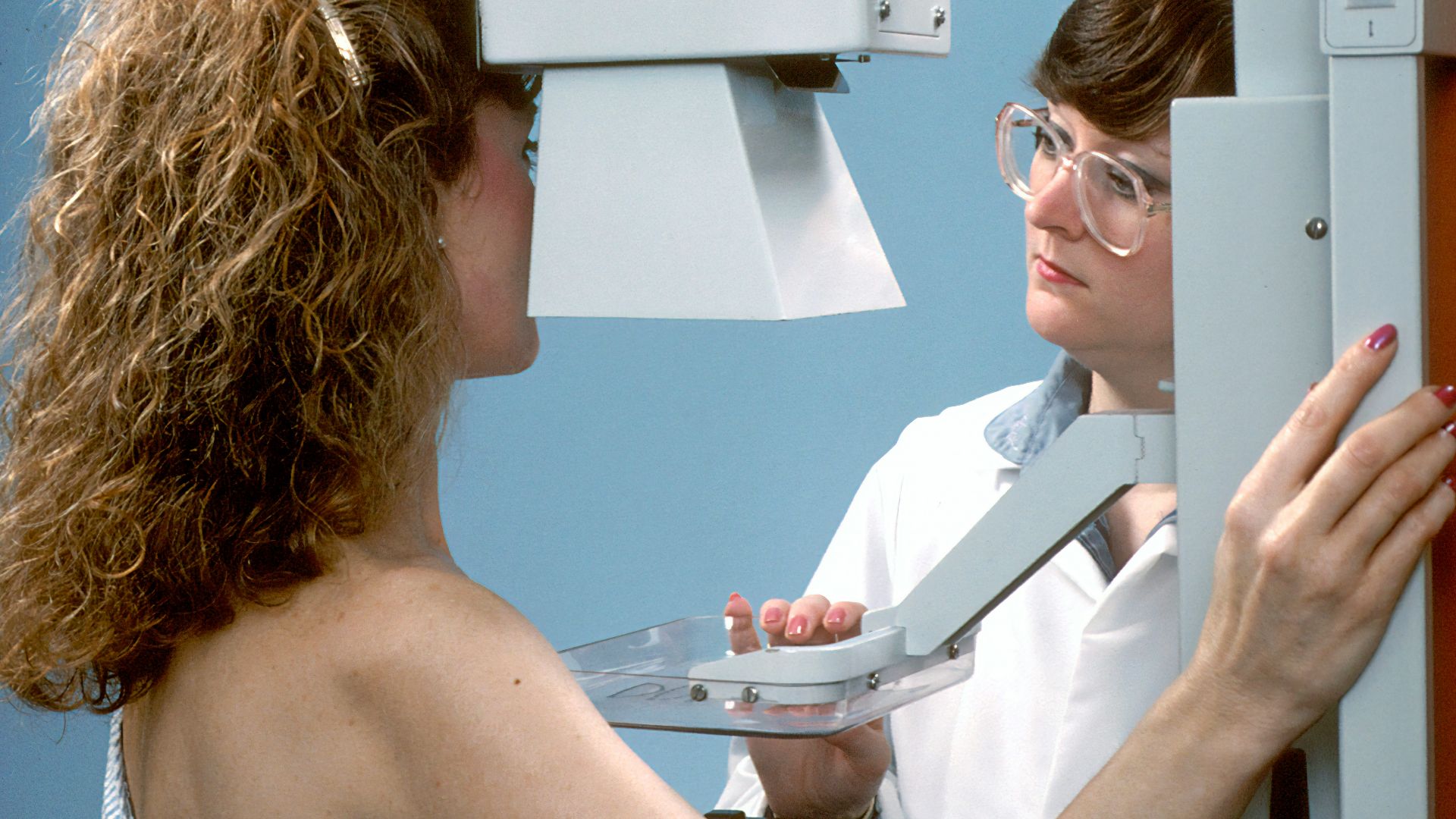 woman in white tube top holding white printer paper