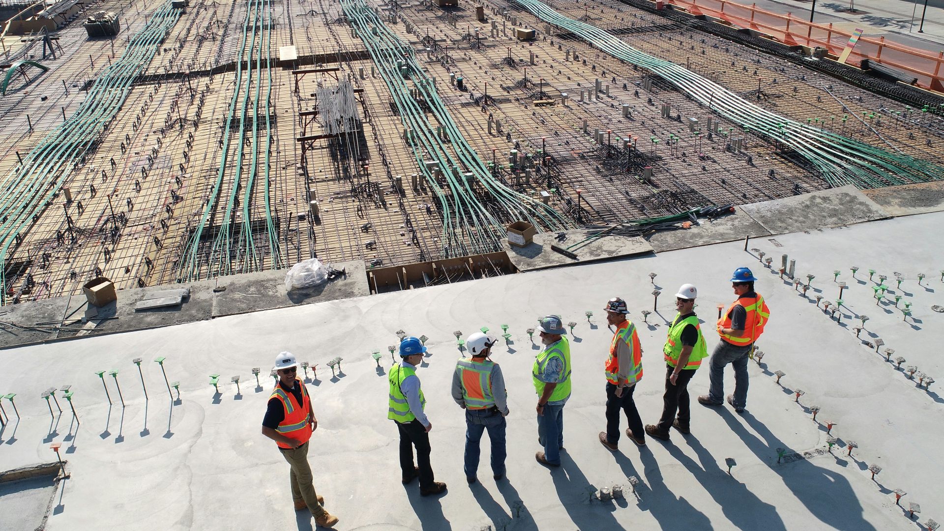 seven construction workers standing on white field