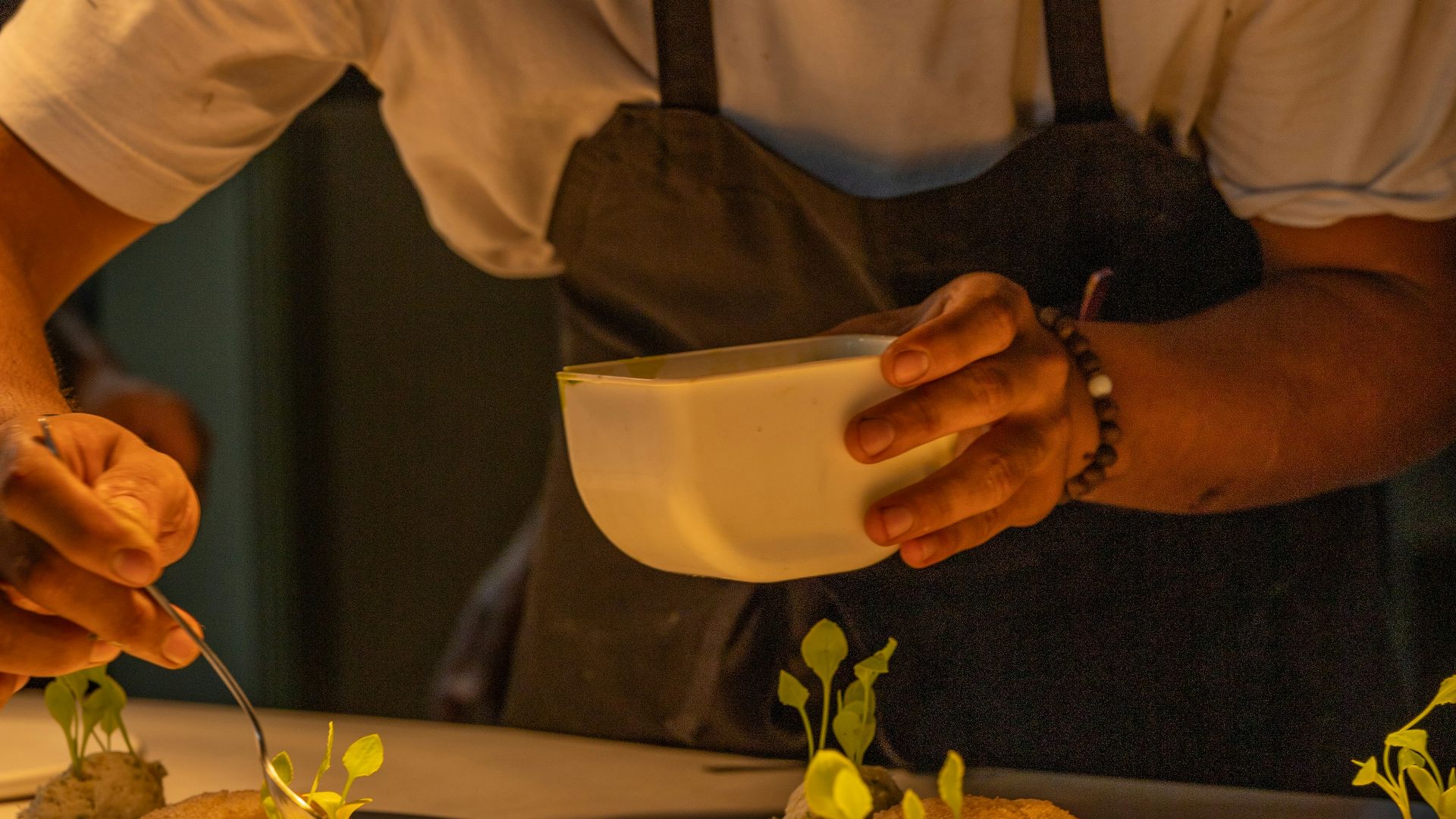 A man in a hat is preparing food on a table