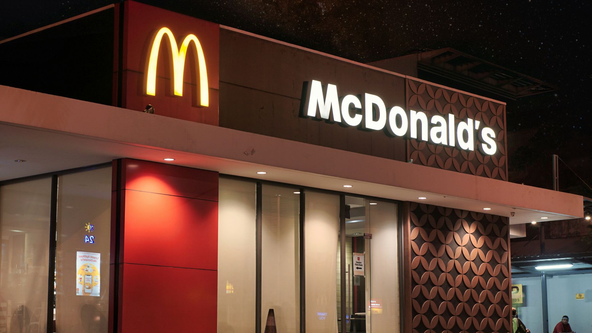 a mcdonald's restaurant is lit up at night