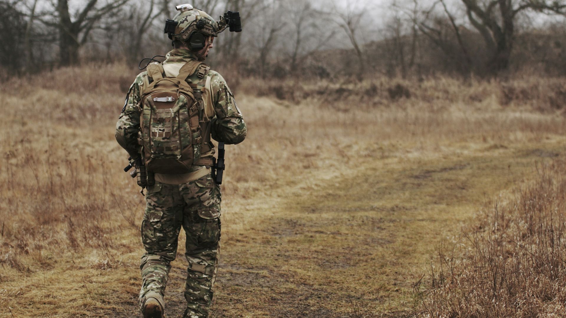 man walking on brown grass field