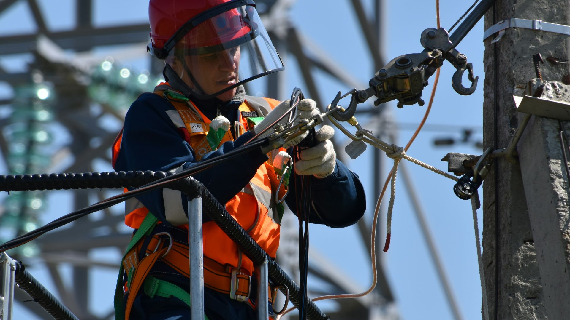 shallow focus photo of man fixing steel cable
