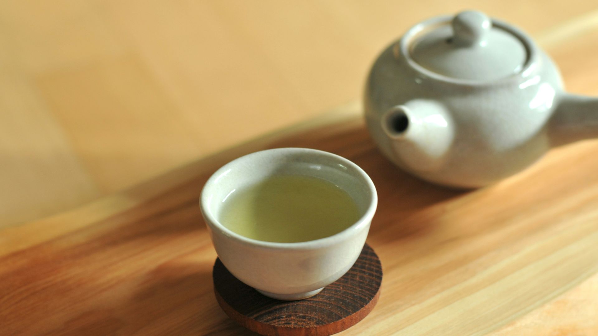 white ceramic teacup on brown wooden table