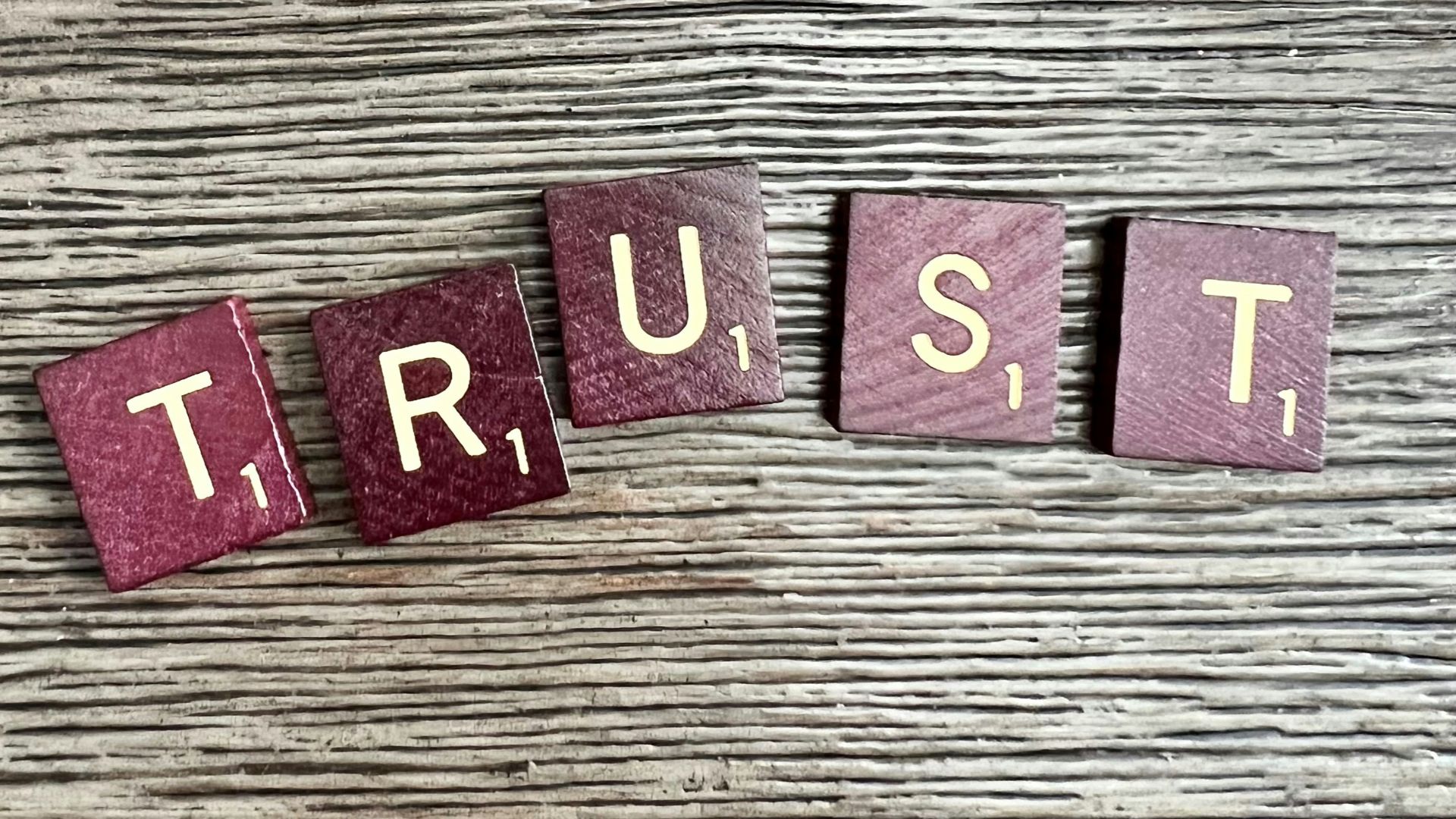 trust spelled with wooden letter blocks on a table