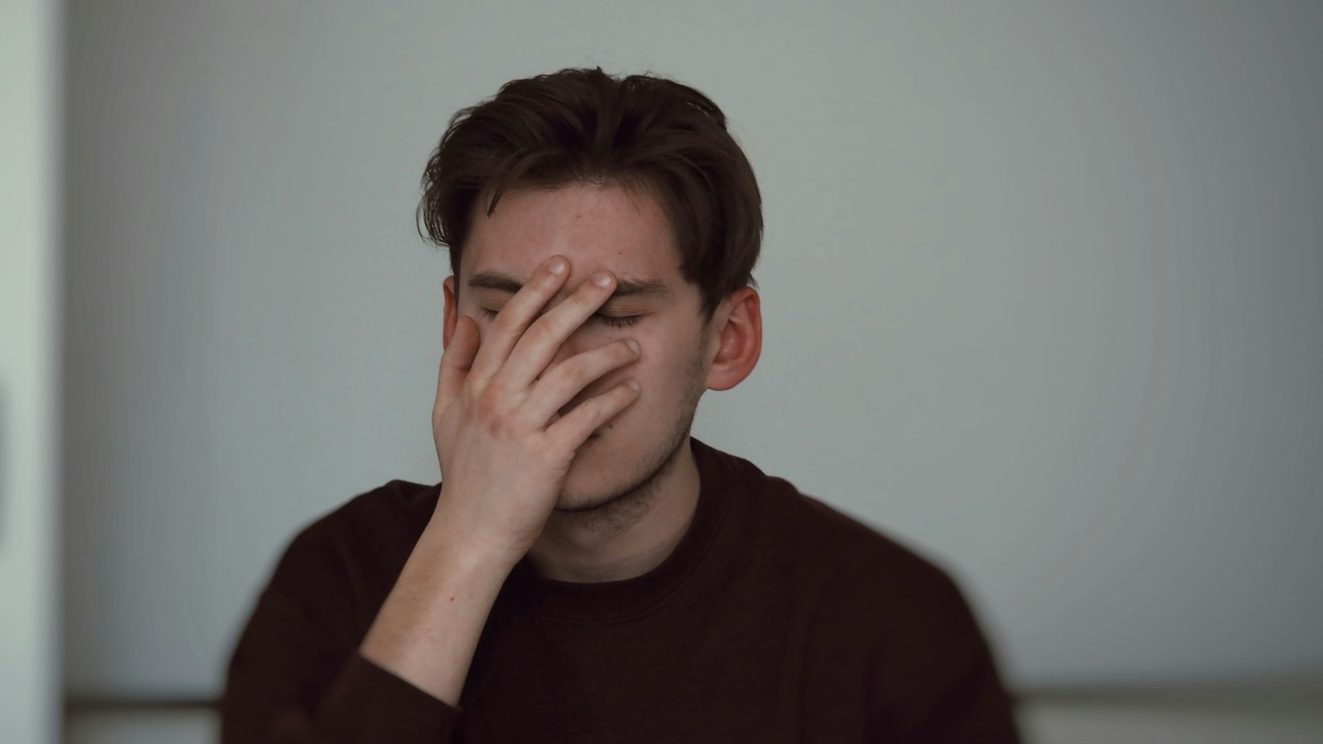 man covering his face