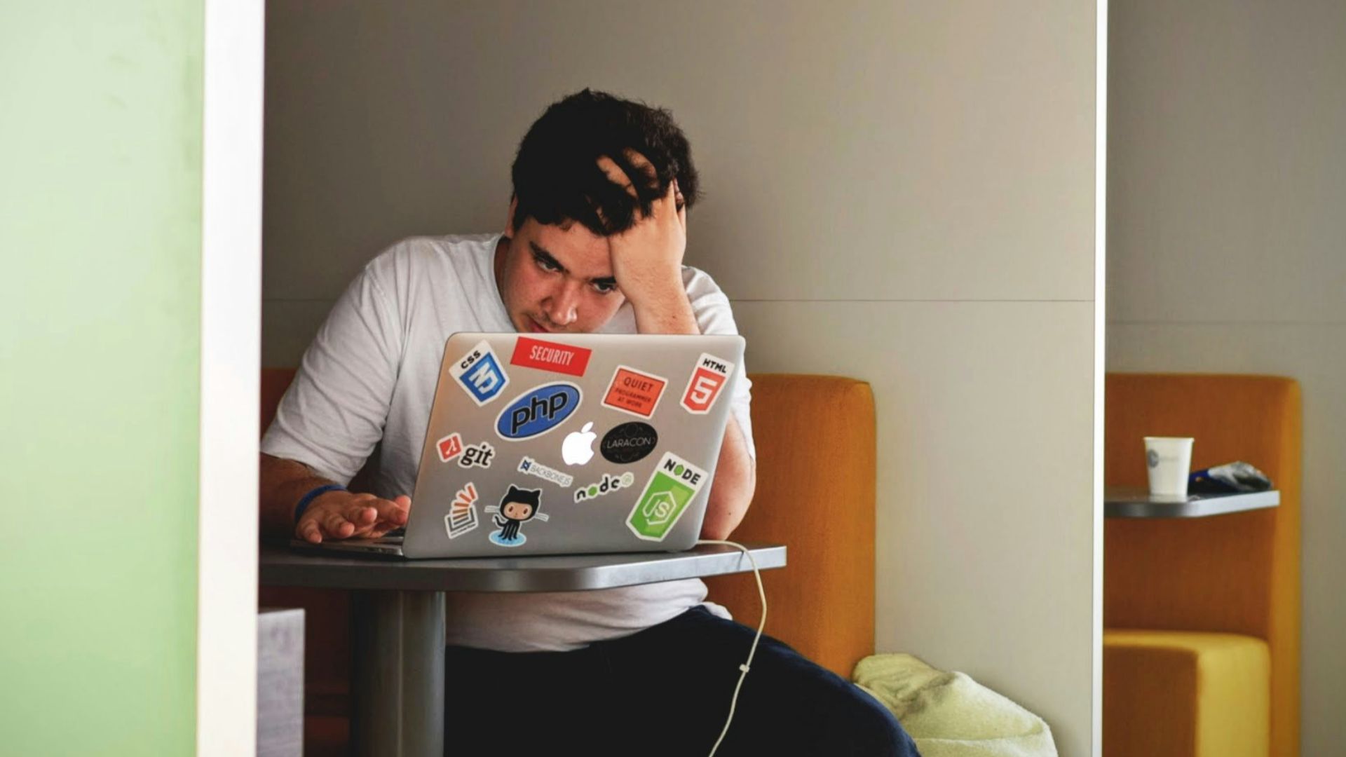man wearing white top using MacBook