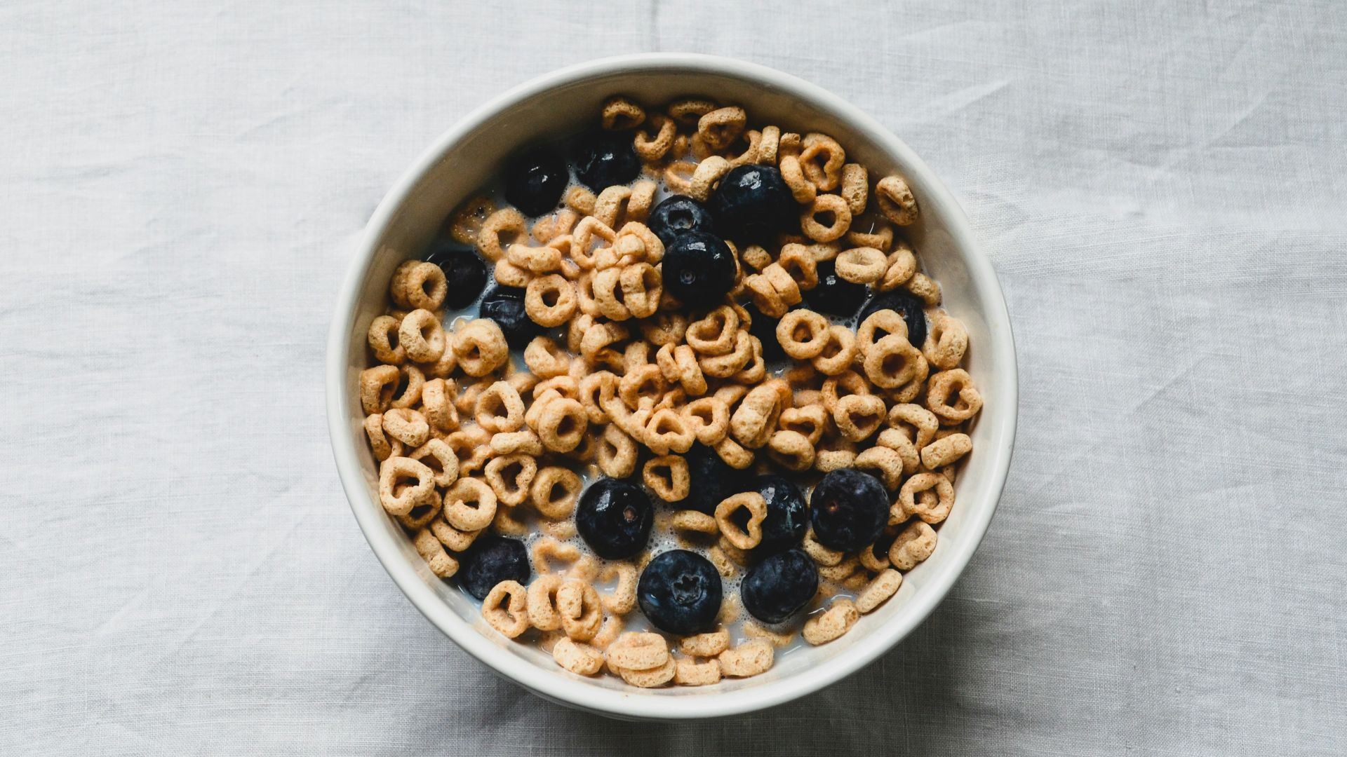 a white bowl filled with cereal and blueberries