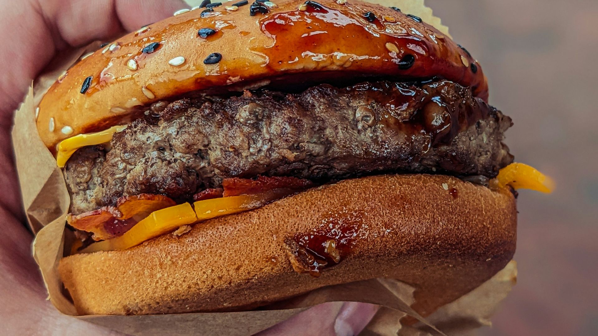 a person holding a hamburger in their hand