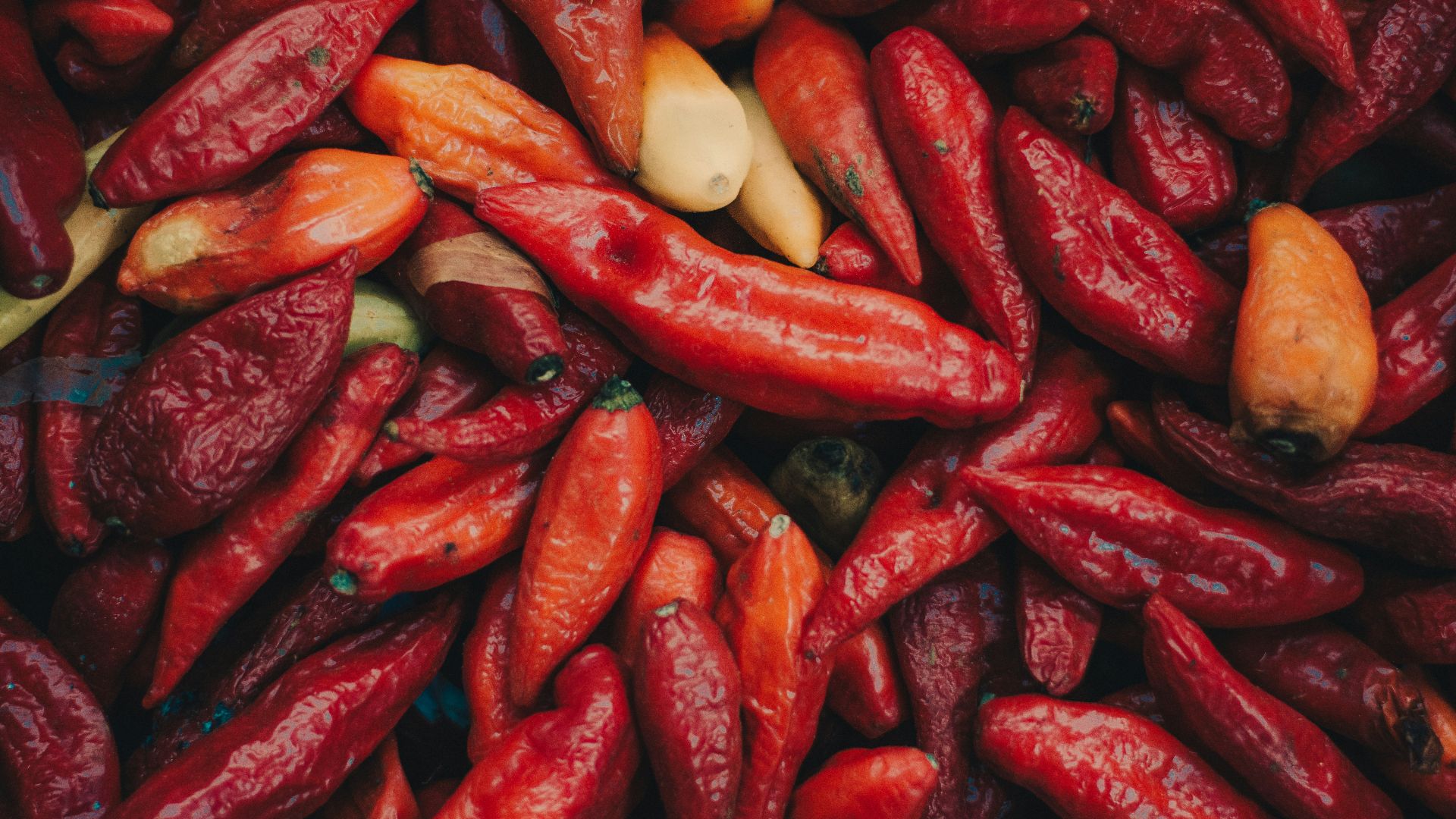 a pile of red peppers and other vegetables