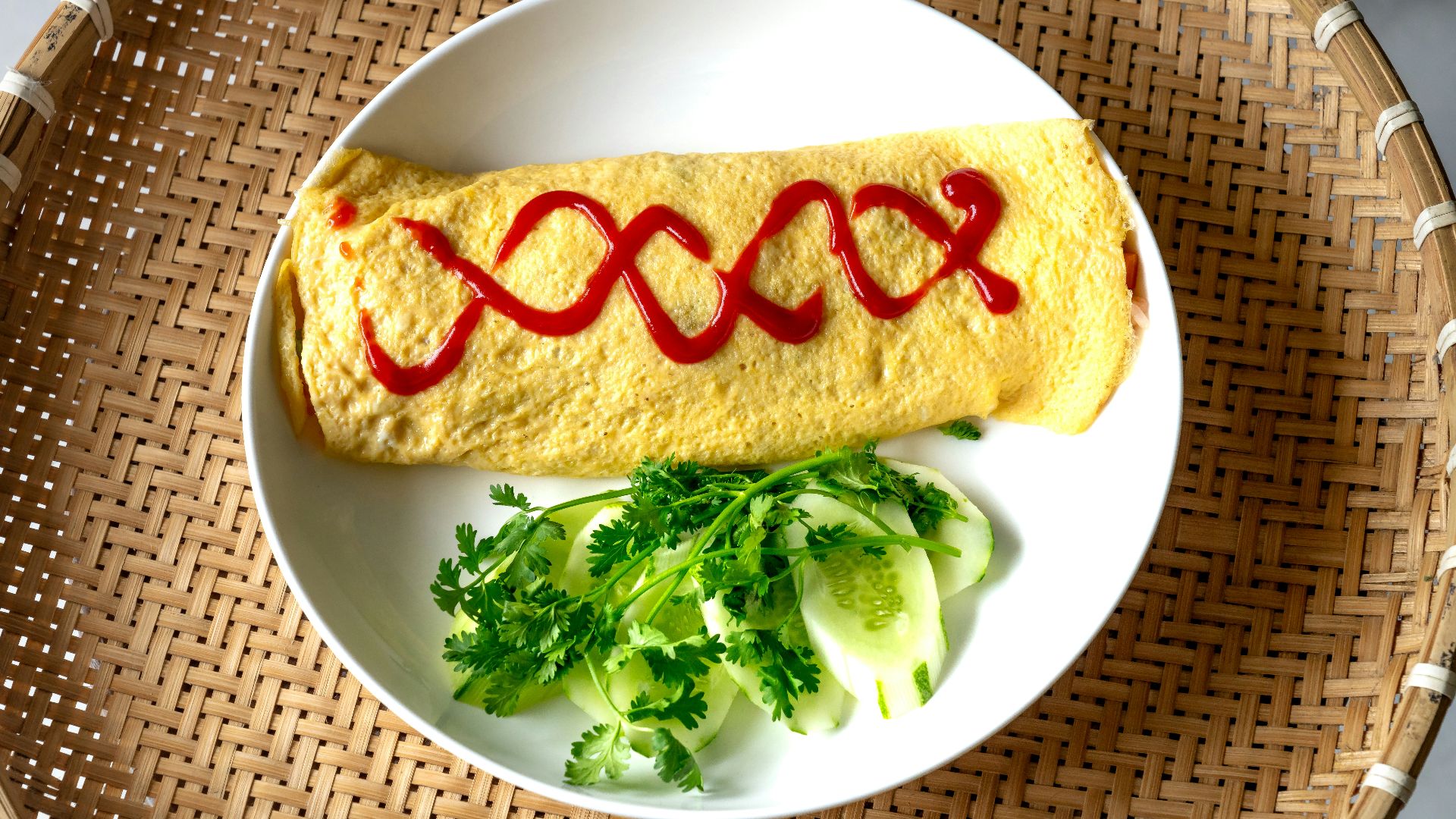 a white plate topped with an omelet covered in sauce
