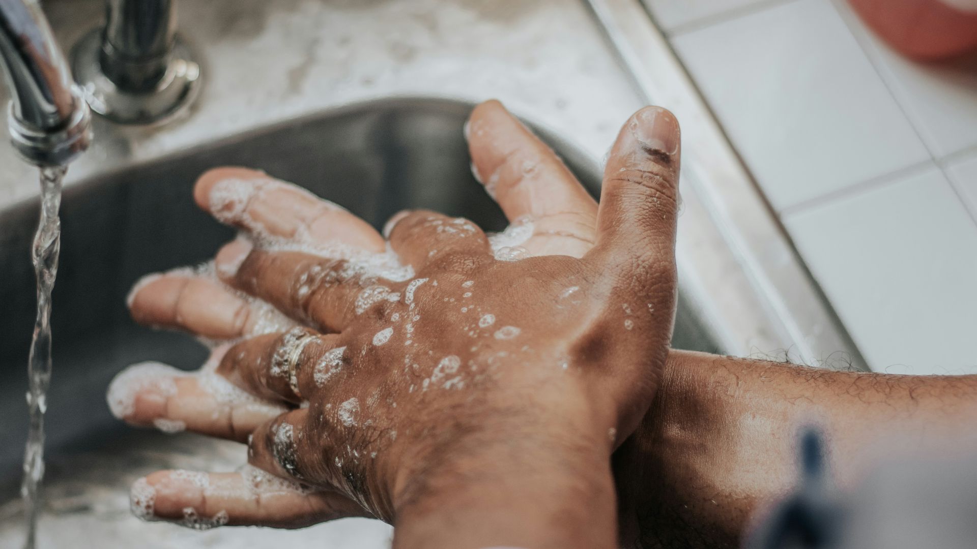 person in white shirt washing hands