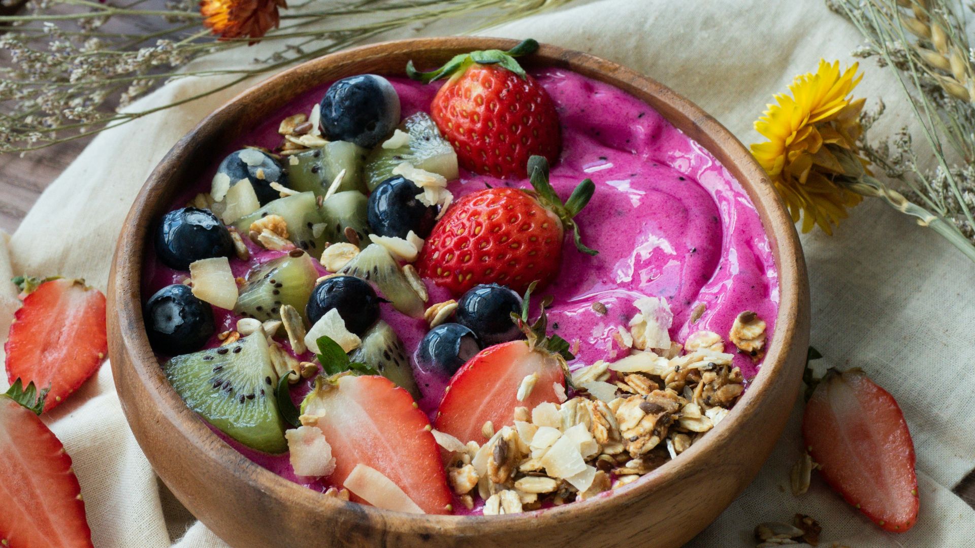red and black berries on brown wooden bowl