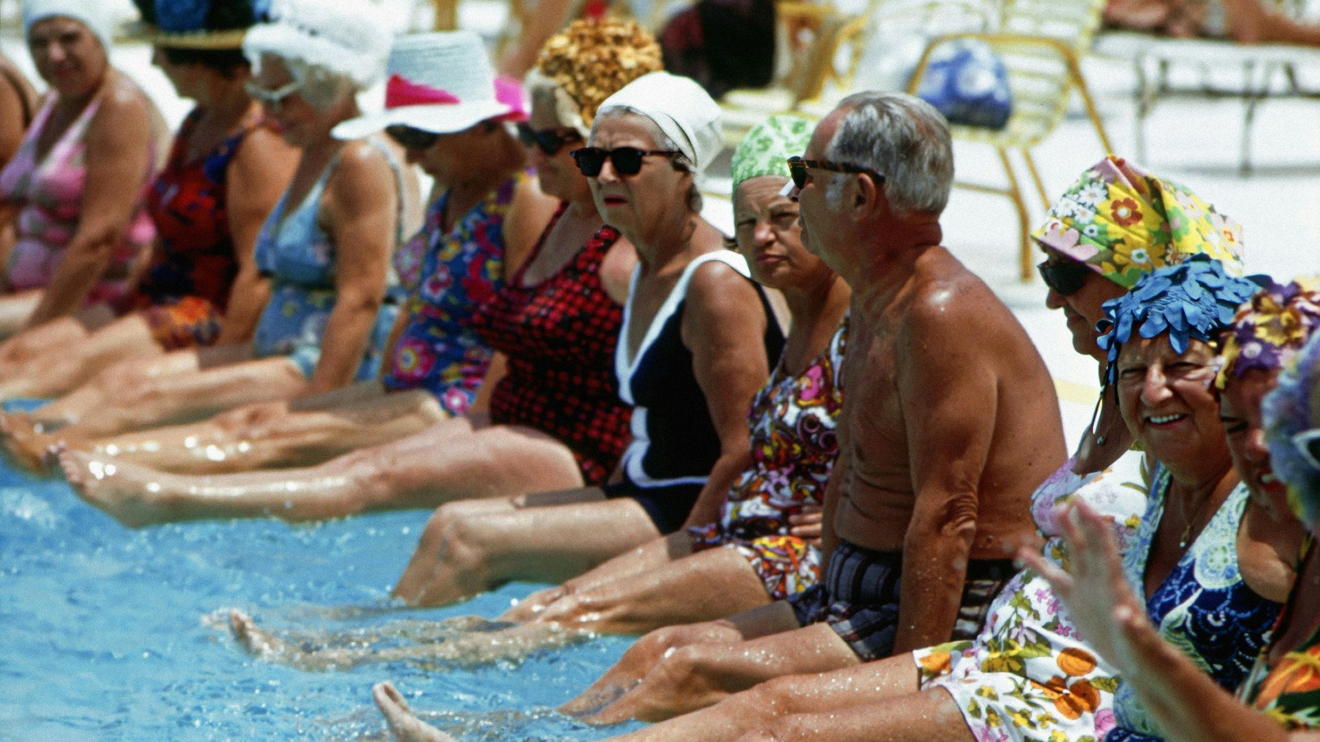a group of people sitting next to each other in a swimming pool