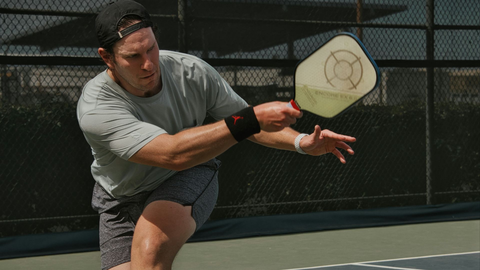 man in gray crew neck t-shirt and gray shorts sitting on basketball court