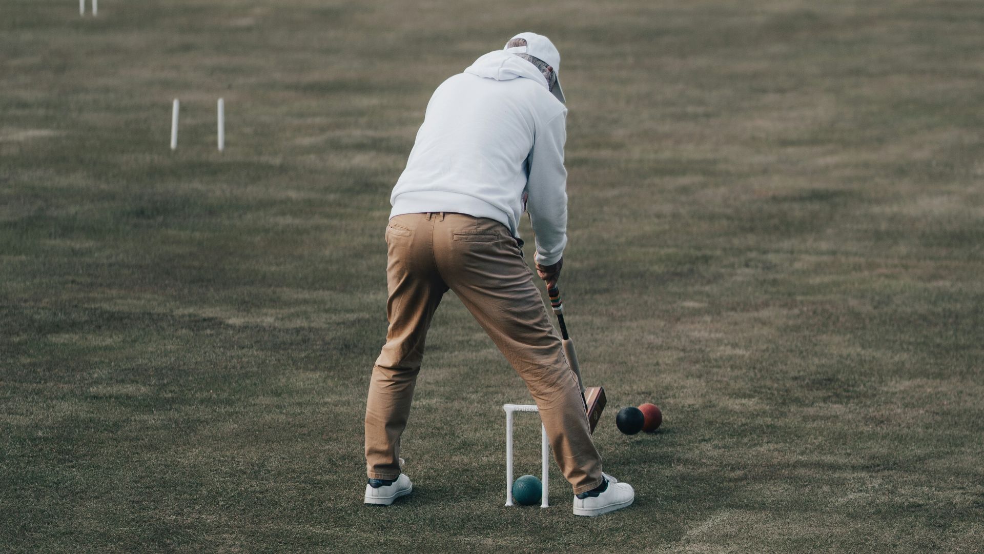 man in white t-shirt playing golf during daytime